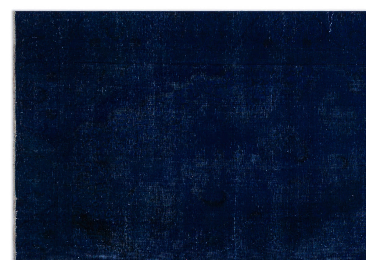 Solid deep navy blue rug with a subtle, distressed tonal medallion pattern.