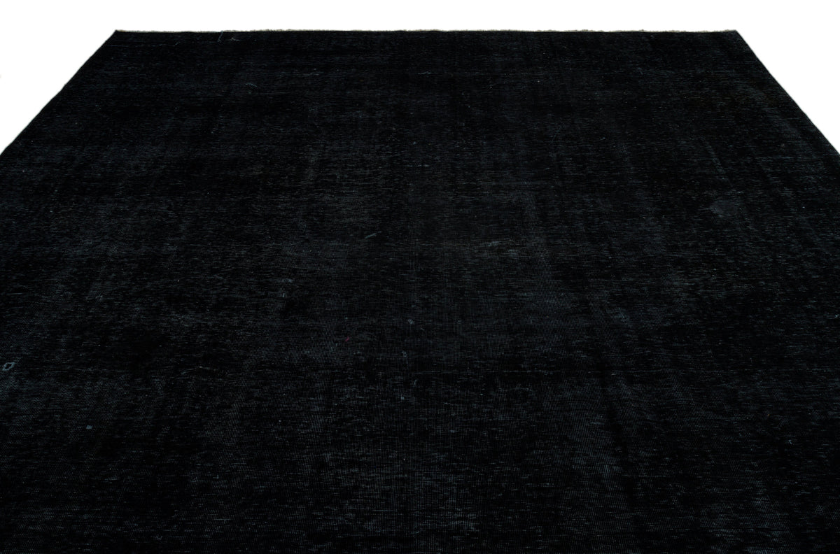 Solid black rug with a subtle, distressed vintage texture on a white background.