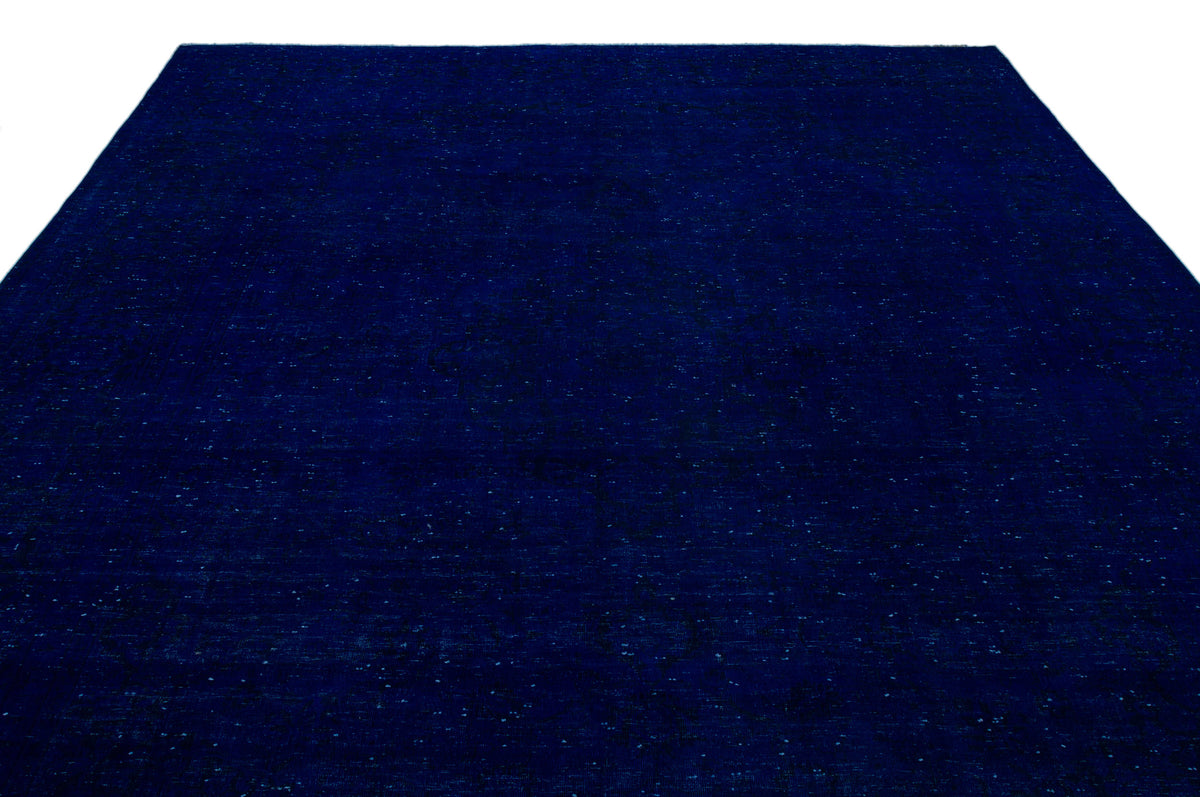 Solid deep navy blue rug with a subtle, distressed tonal texture and faint, dark geometric pattern.