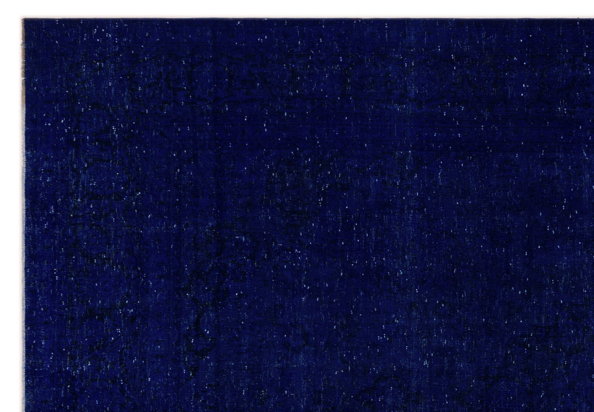 Deep navy blue rug with a subtle, distressed tonal medallion pattern and white flecked texture.