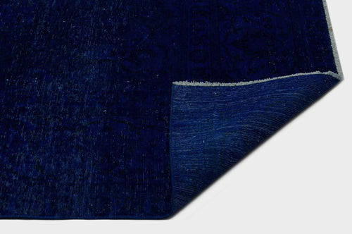 Load image 1 in gallery view. Deep blue distressed rug with a faint traditional medallion pattern and a folded corner revealing the woven backing.