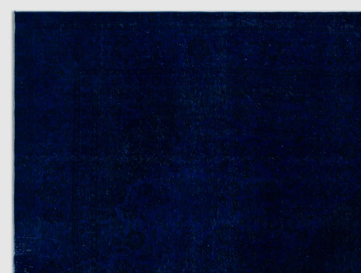 Deep navy blue rug with a subtle, tonal traditional floral pattern and a bordered edge.