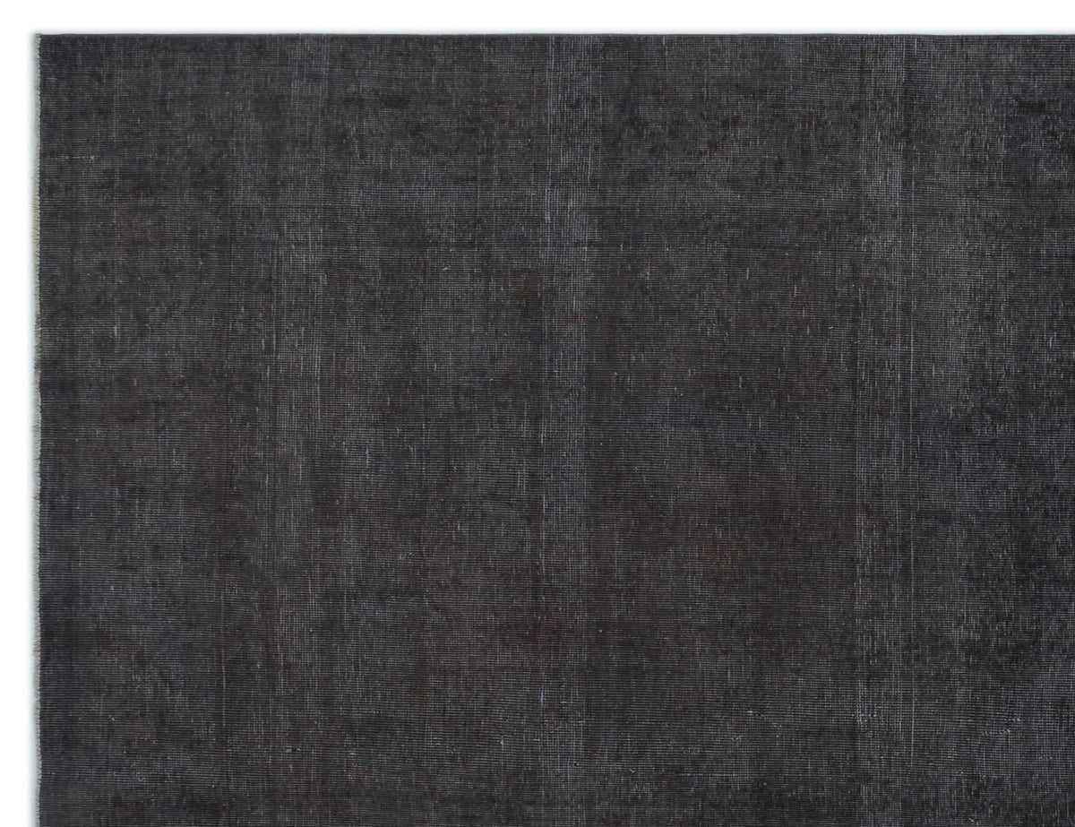 Solid charcoal black rug with a subtle, distressed vintage texture and visible weave.