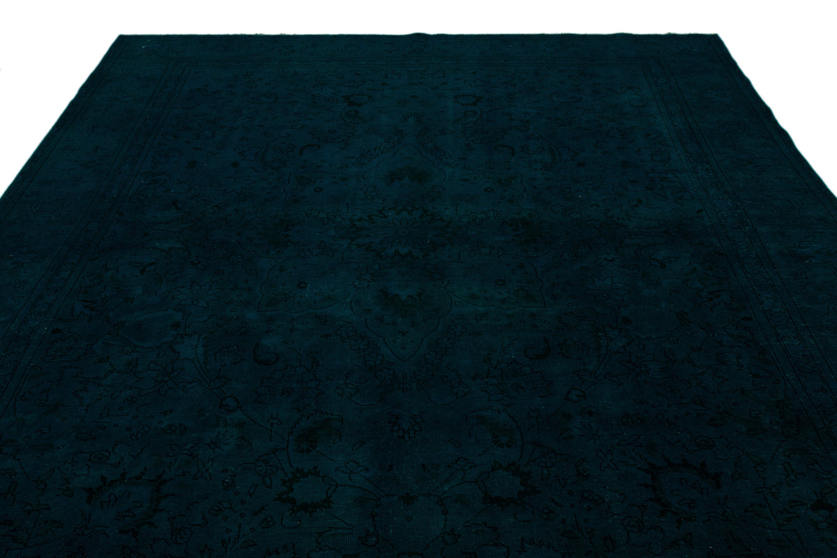 Dark teal monochromatic rug with a subtle, tone-on-tone traditional floral medallion pattern.