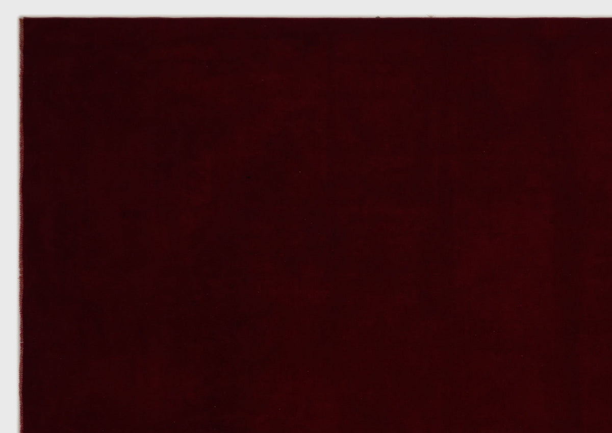 Solid deep burgundy rug with a smooth, uniform texture on a white background.