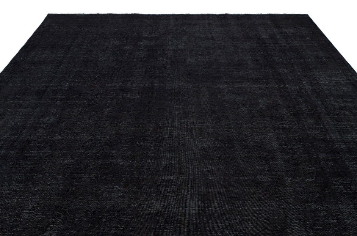 Solid black rug with a subtle, distressed vintage-style pattern and a thin border, isolated on a white background.