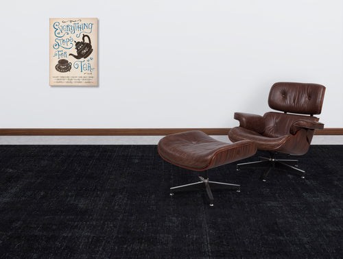 Load image 1 in gallery view. Solid black distressed-texture rug in a modern living room with a brown leather lounge chair.