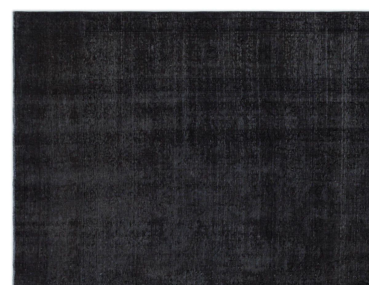 Solid black rug with a distressed, faded texture and subtle tonal variations.