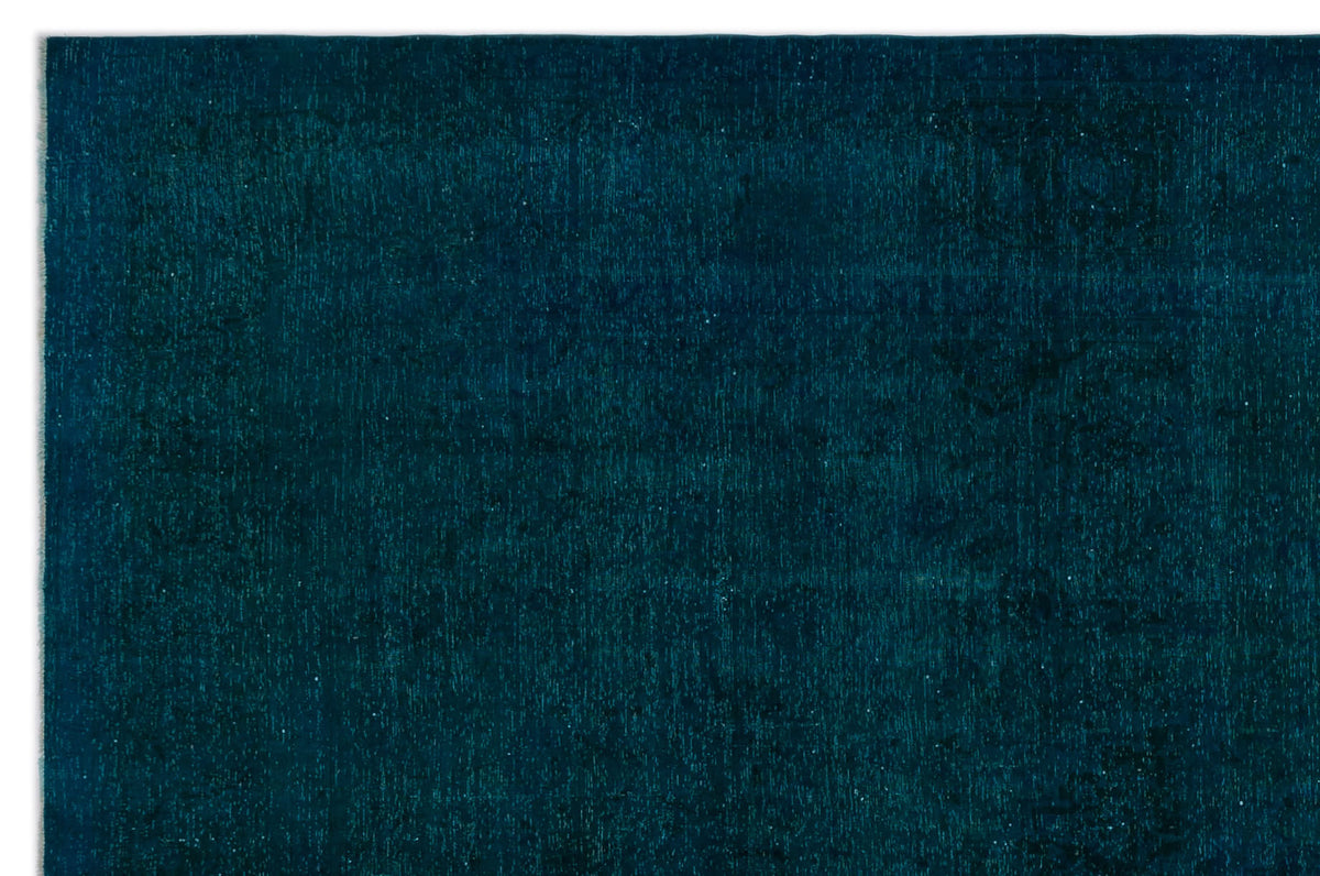 Deep teal monochromatic rug with a subtle, distressed vintage-style pattern.