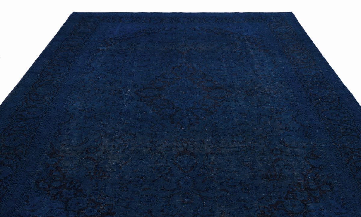 Deep blue traditional rug with a tonal black floral medallion pattern and ornate border on a white background.