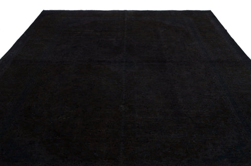 Load image 1 in gallery view. Solid black rug with a subtle, tonal distressed medallion pattern on a white background.