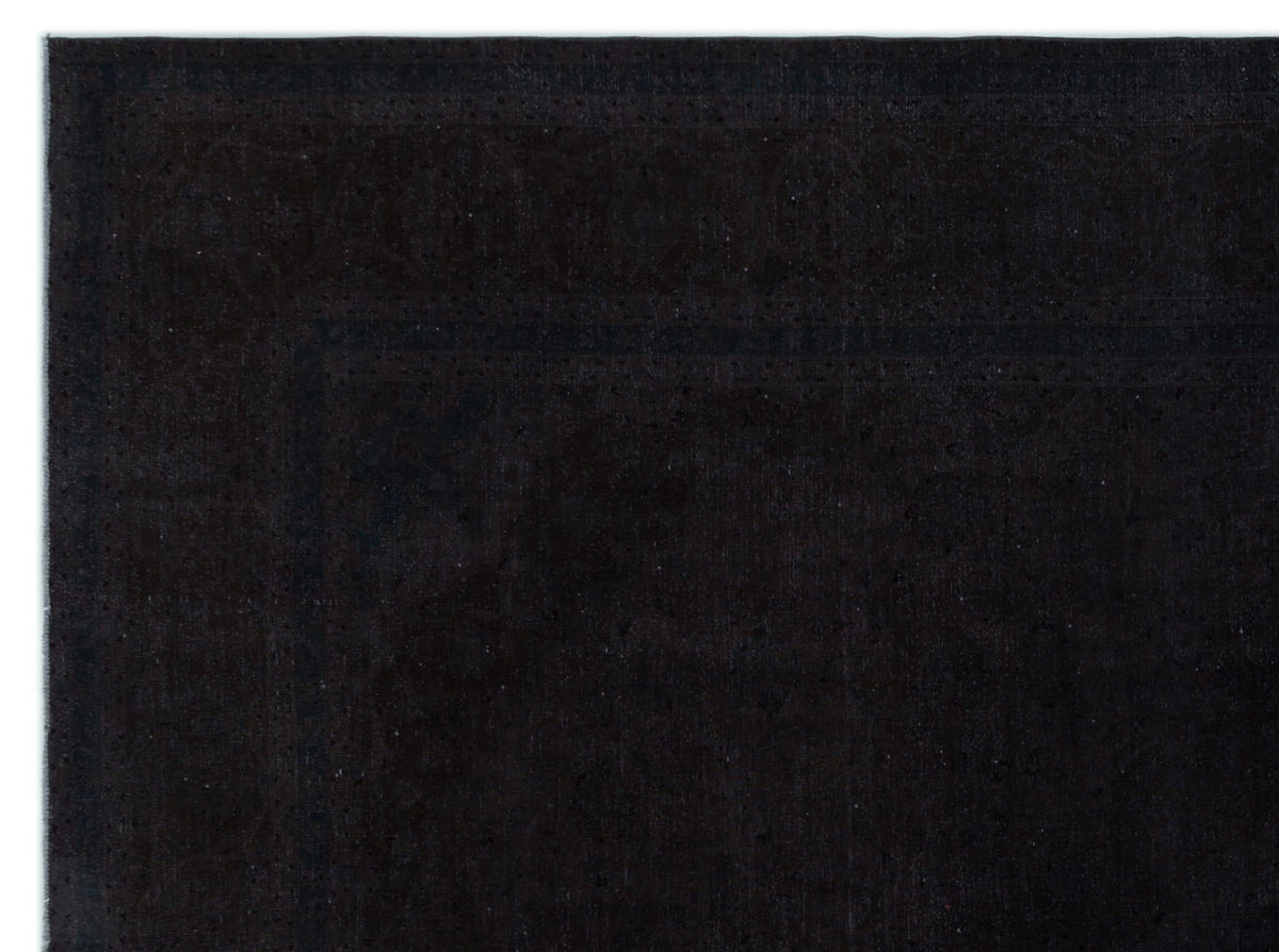 Solid black rug with a subtle, tone-on-tone traditional border pattern on a white background.