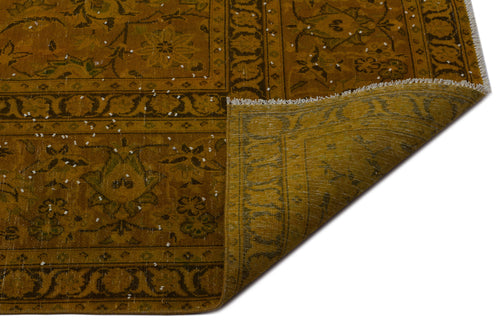 Load image 1 in gallery view. Mustard yellow vintage-style rug with a traditional floral medallion pattern and a folded corner showing the backing.