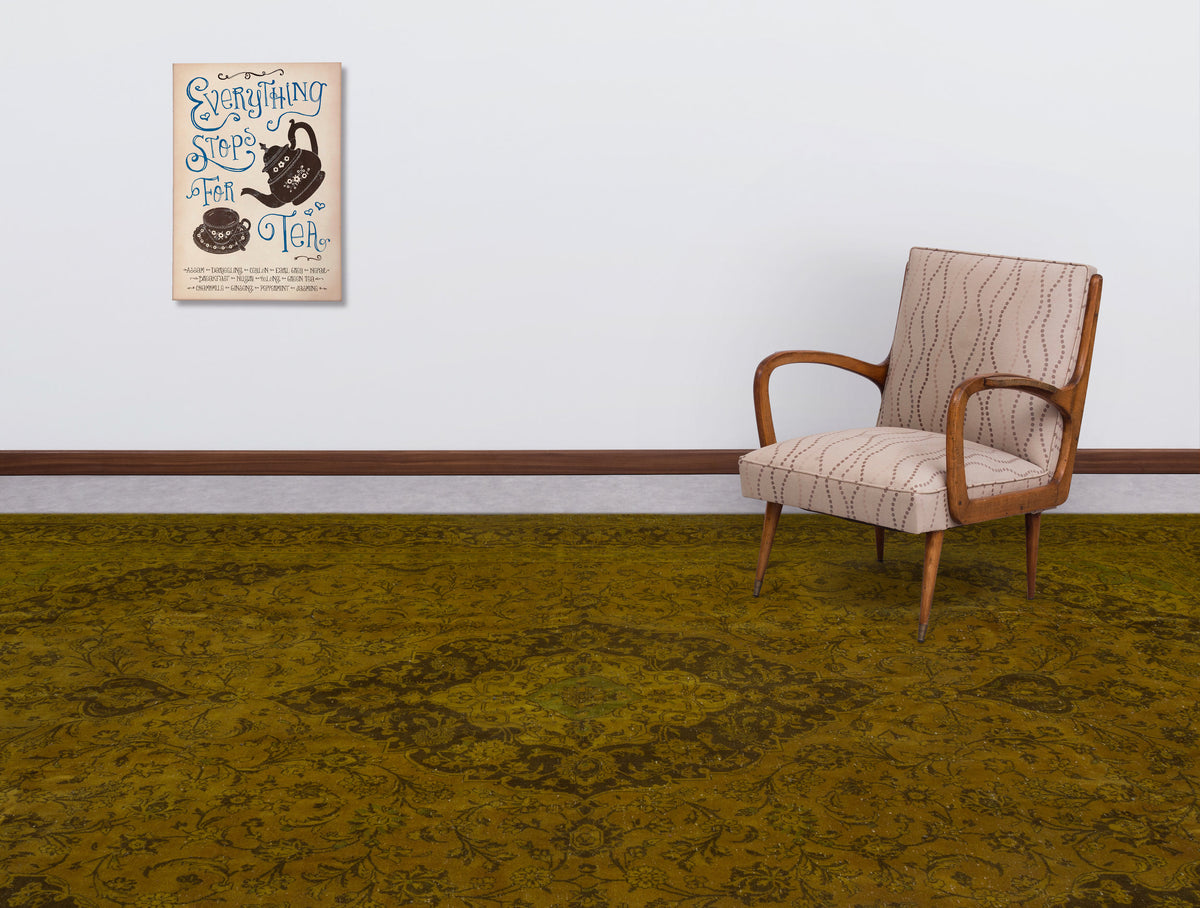 Olive green traditional rug with a dark floral medallion pattern, styled in a room with a patterned armchair.
