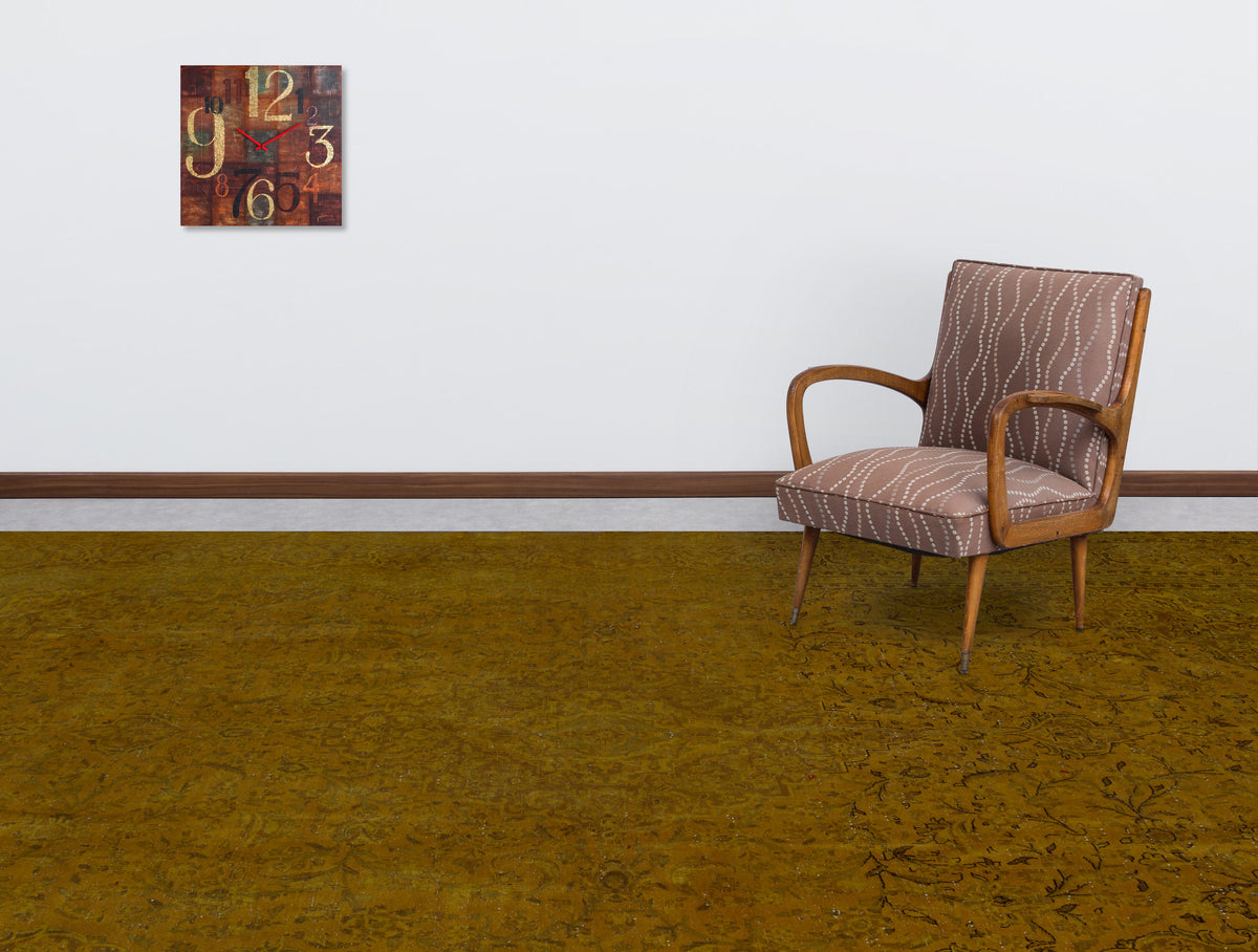 Solid mustard yellow rug with a subtle, tonal traditional pattern, styled in a room with a patterned armchair and clock.