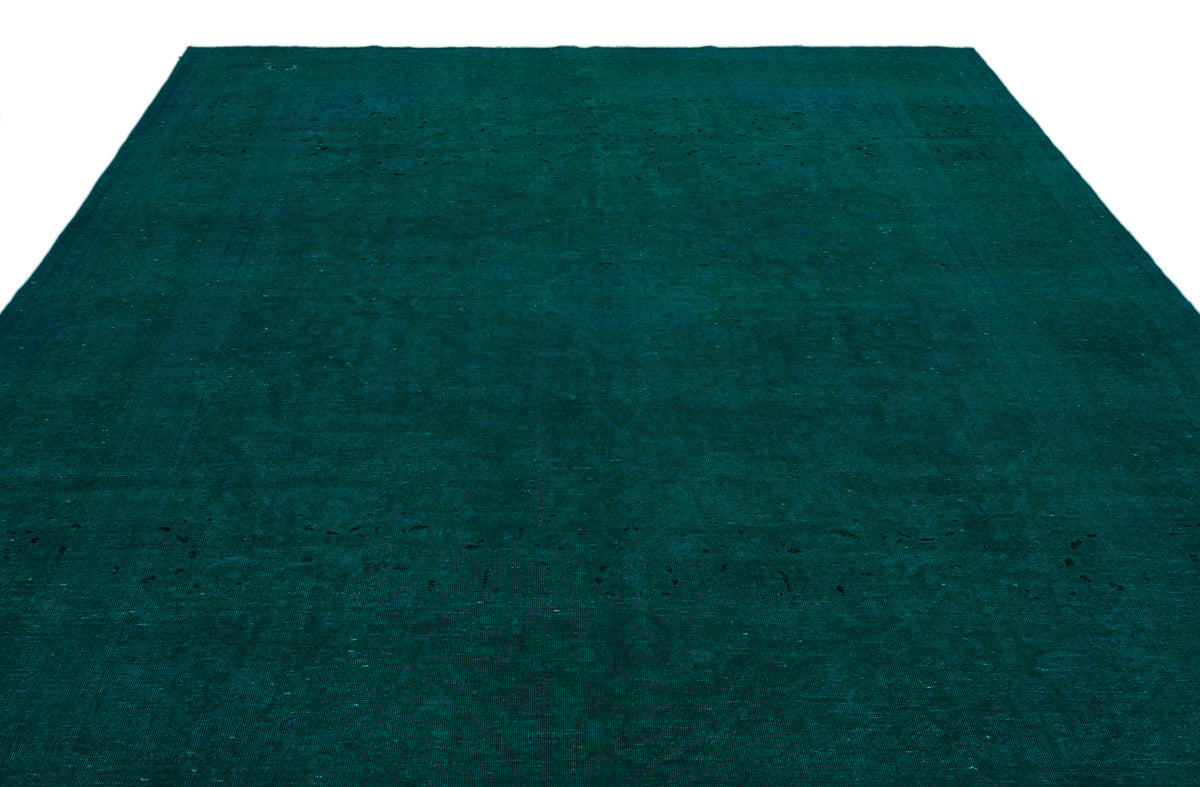 Solid deep teal rug with a subtle, distressed vintage-style texture and faint border detail.