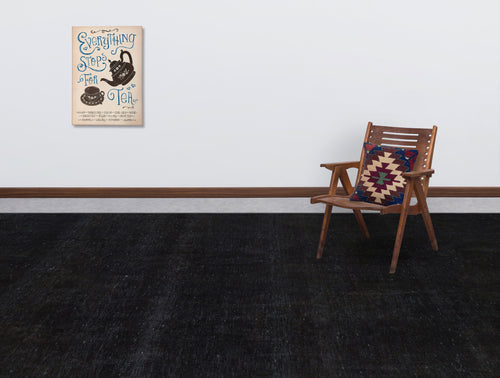 Load image 1 in gallery view. Solid black rug in a room with a wooden chair and tea-themed wall art.