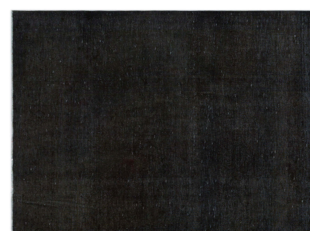 Solid black rug with a subtle, distressed texture and faint white flecks.