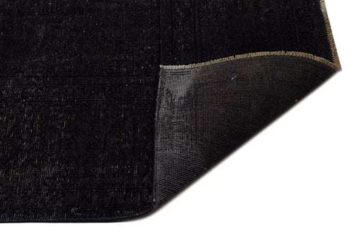 Load image 1 in gallery view. Distressed black rug with a folded corner revealing the dark grey woven backing and tan fringe.
