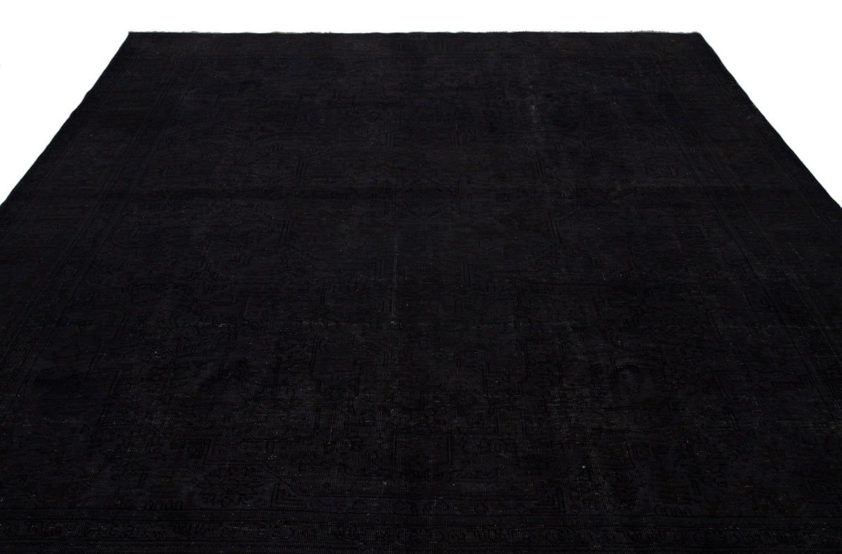 Solid black rug with a subtle, tonal traditional medallion pattern on a white background.