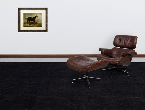 Load image 1 in gallery view. Solid black rug with a subtle tonal traditional pattern, styled in a room with a brown leather lounge chair.