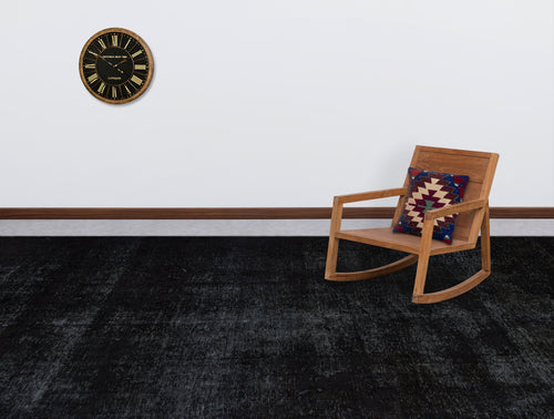 Load image 1 in gallery view. Solid black distressed-texture rug in a room with a wooden rocking chair and wall clock.