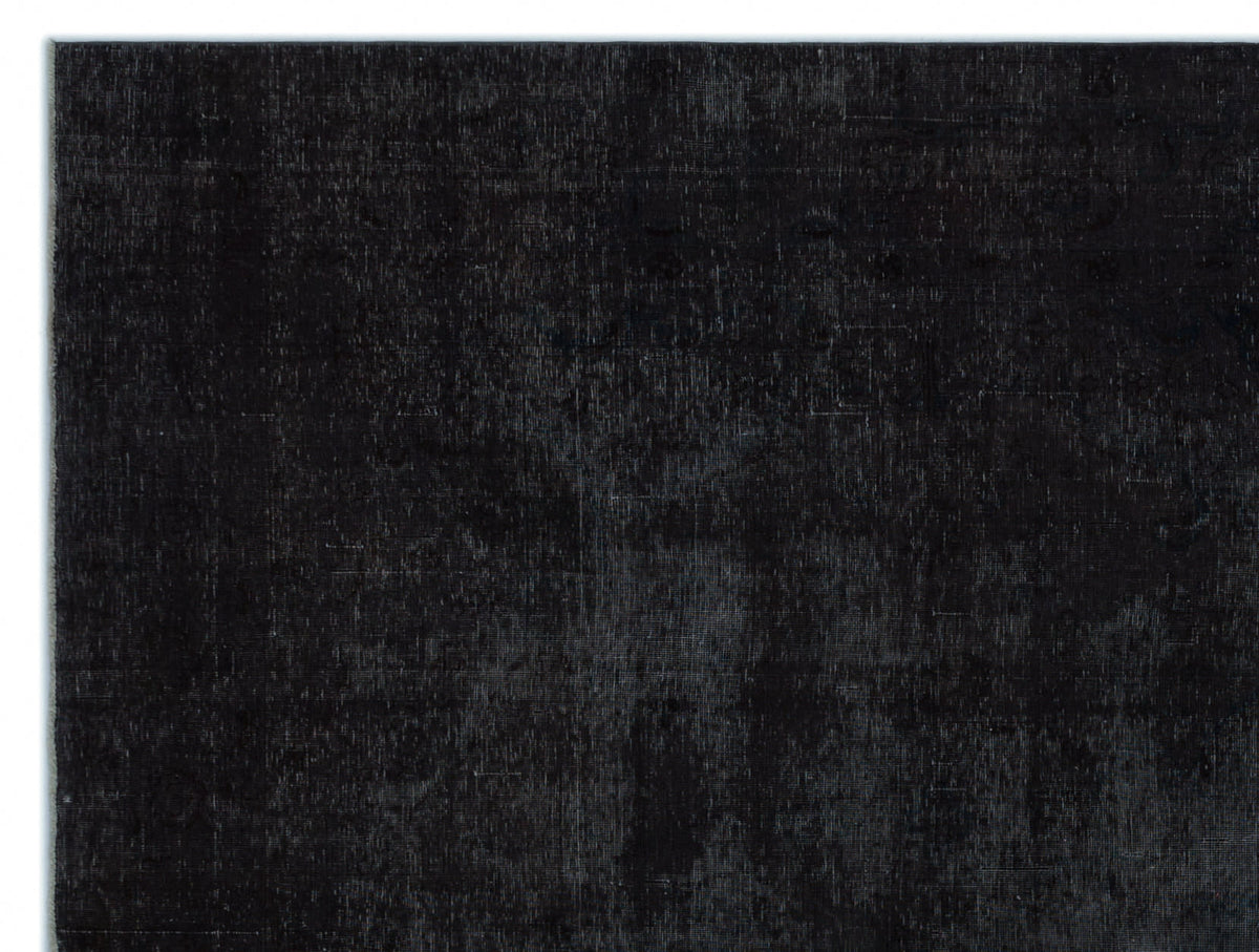 Solid black rug with a distressed, vintage-style texture on a white background.