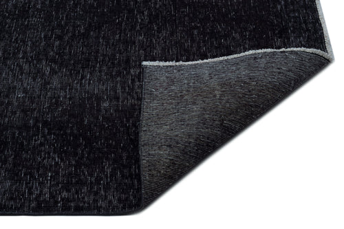 Load image 1 in gallery view. Black distressed-texture rug with a folded corner revealing a grey woven backing on a white background.