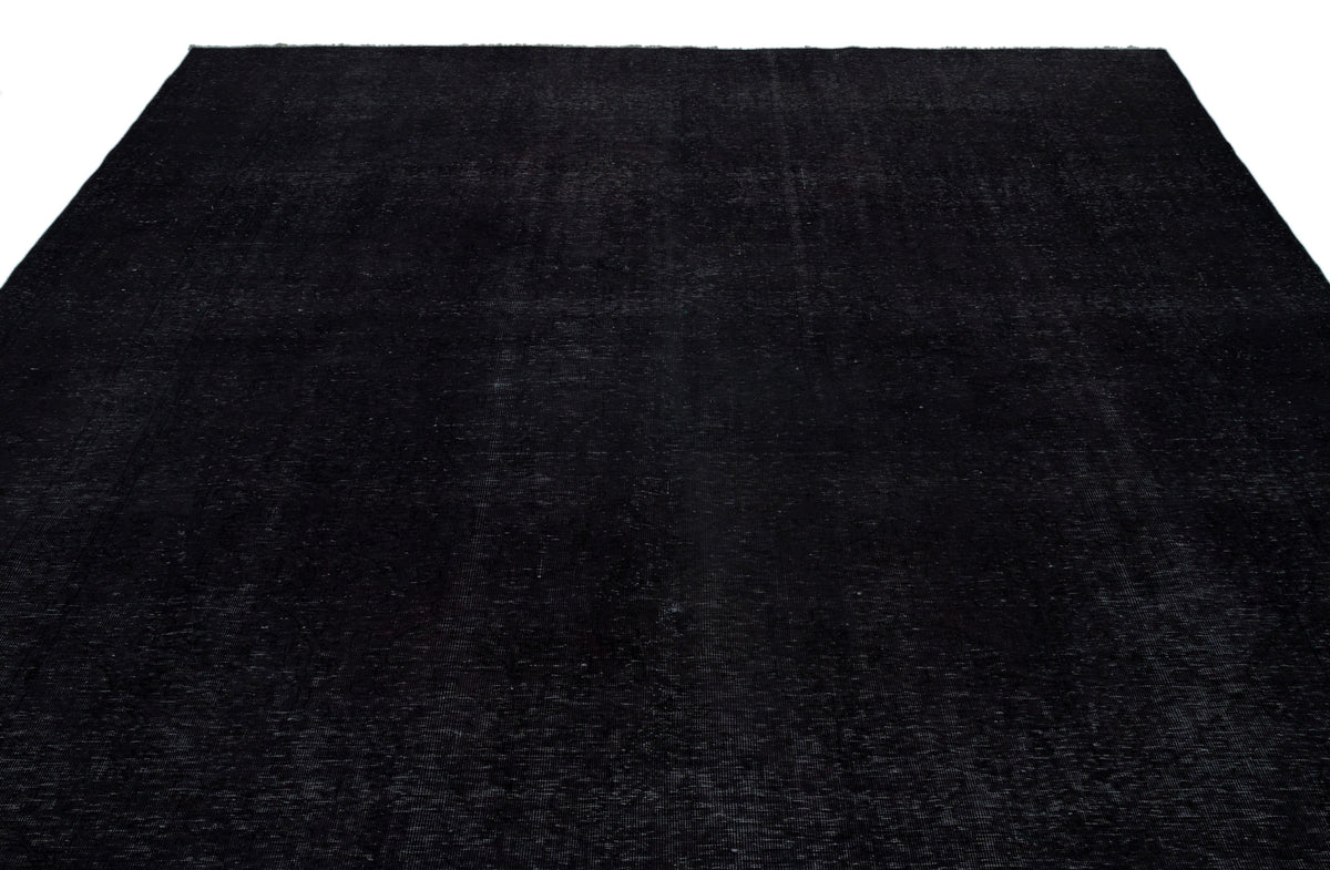 Solid black rug with a subtle, distressed vintage texture on a white background.