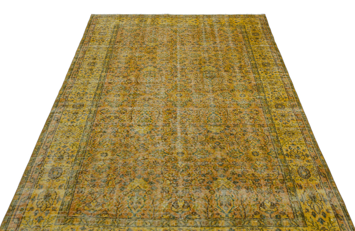 Mustard yellow and olive green vintage-style rug with a distressed traditional floral medallion pattern.