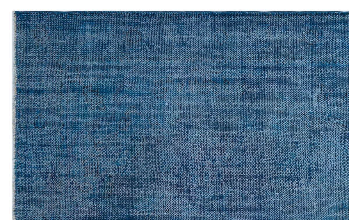 Solid blue rug with a distressed, textured weave and subtle horizontal tonal variations.