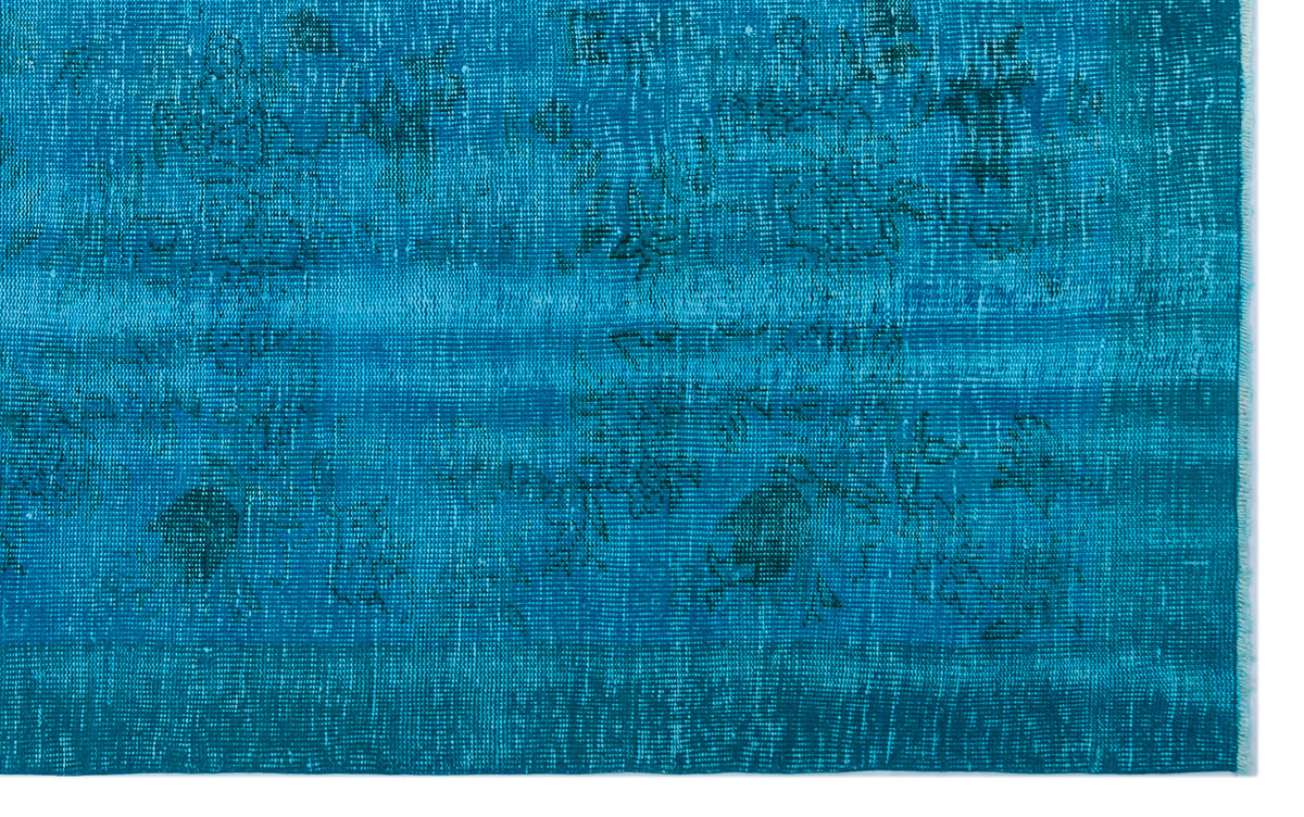 Teal blue distressed rug with a faded, overdyed vintage pattern and visible woven texture.