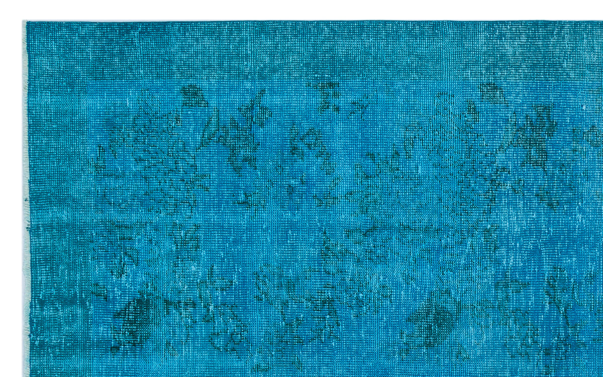 Teal distressed rug with a faint, tonal floral medallion pattern.