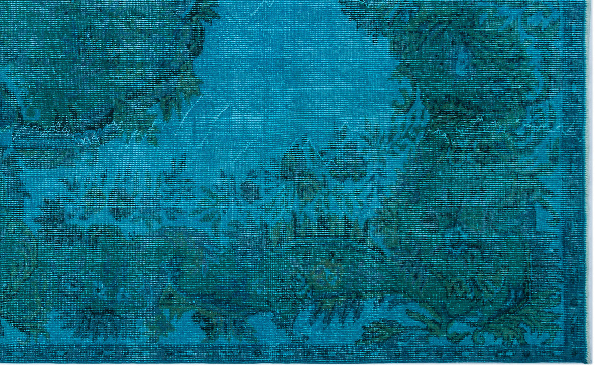 Teal and dark blue rug with a distressed, traditional floral medallion pattern.