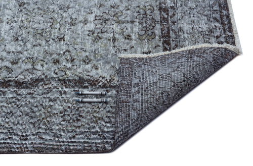 Load image 1 in gallery view. Grey and brown distressed traditional patterned rug with a folded corner showing the woven backing and two crayons.