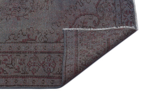 Load image 1 in gallery view. Charcoal and burgundy distressed rug with a traditional floral pattern, shown with a folded corner on a white background.