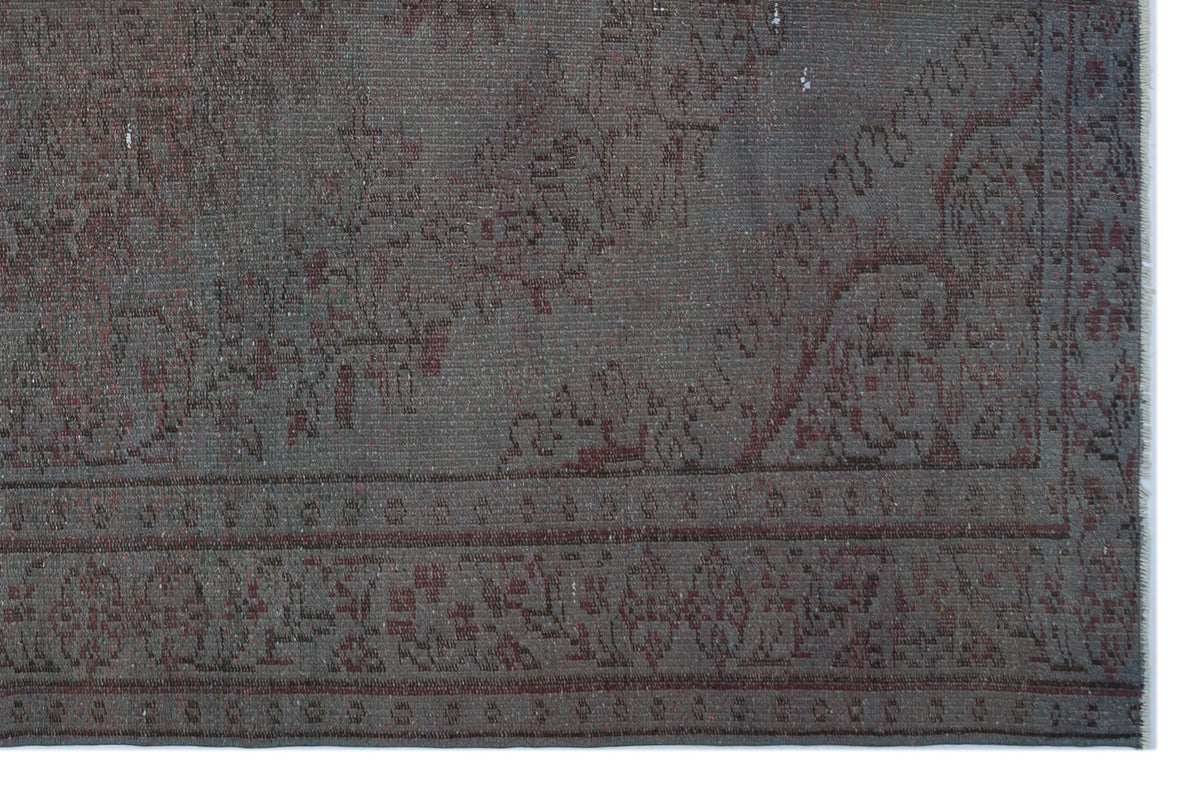 Charcoal and dark red rug with a distressed traditional floral medallion pattern and a detailed border.