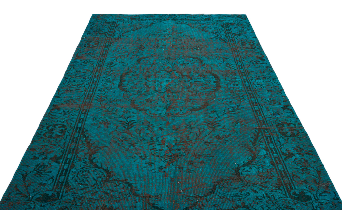 Teal and black distressed rug with a central floral medallion and ornate border pattern on a white background.