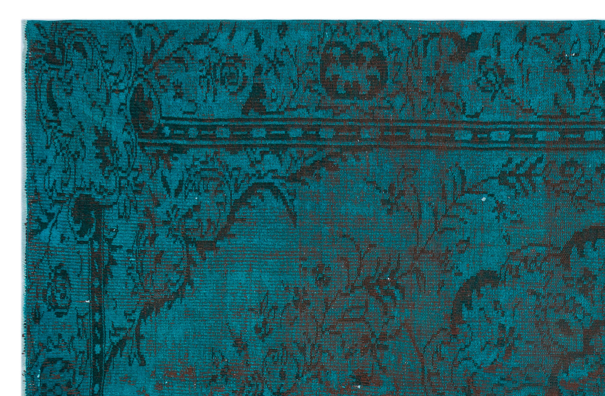 Teal and dark brown rug with a distressed traditional floral medallion pattern.