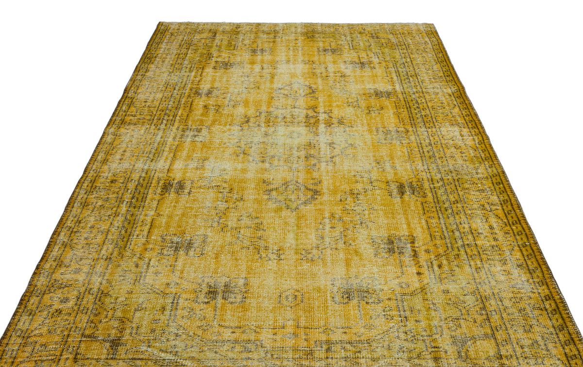 Mustard yellow and charcoal distressed vintage-style rug with a faded central medallion and ornate border.