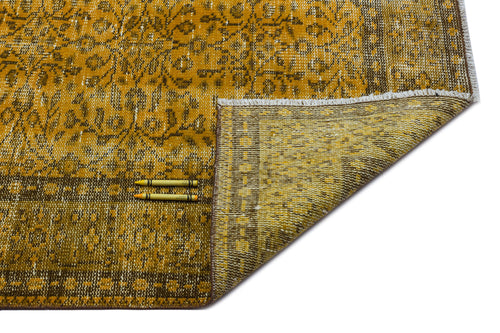 Load image 1 in gallery view. Mustard yellow and brown traditional rug with a floral medallion pattern, shown with a corner folded over.