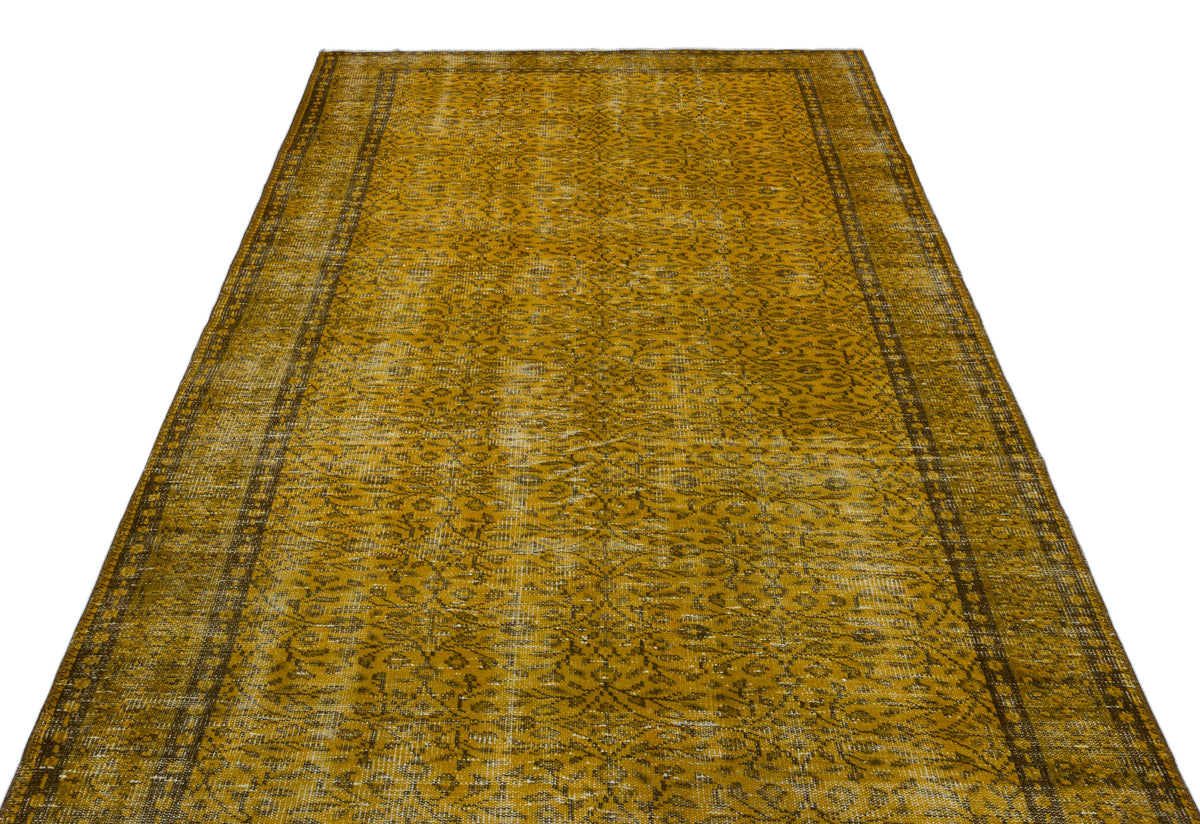 Mustard yellow vintage-style rug with a distressed floral pattern and dark border on a white background.