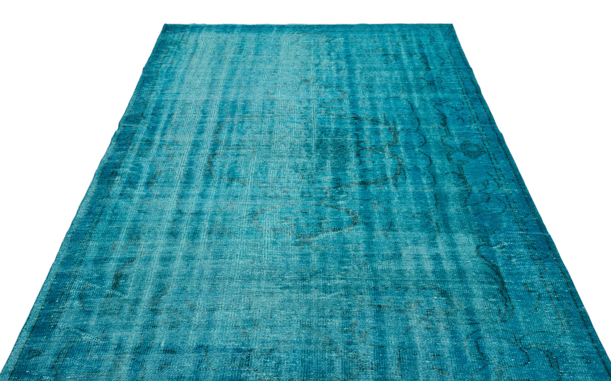 Teal distressed area rug with a faded traditional medallion pattern on a white background.