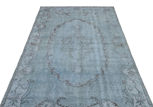 Load image 1 in gallery view. Light blue distressed rug with a faded central medallion and floral border pattern on a white background.