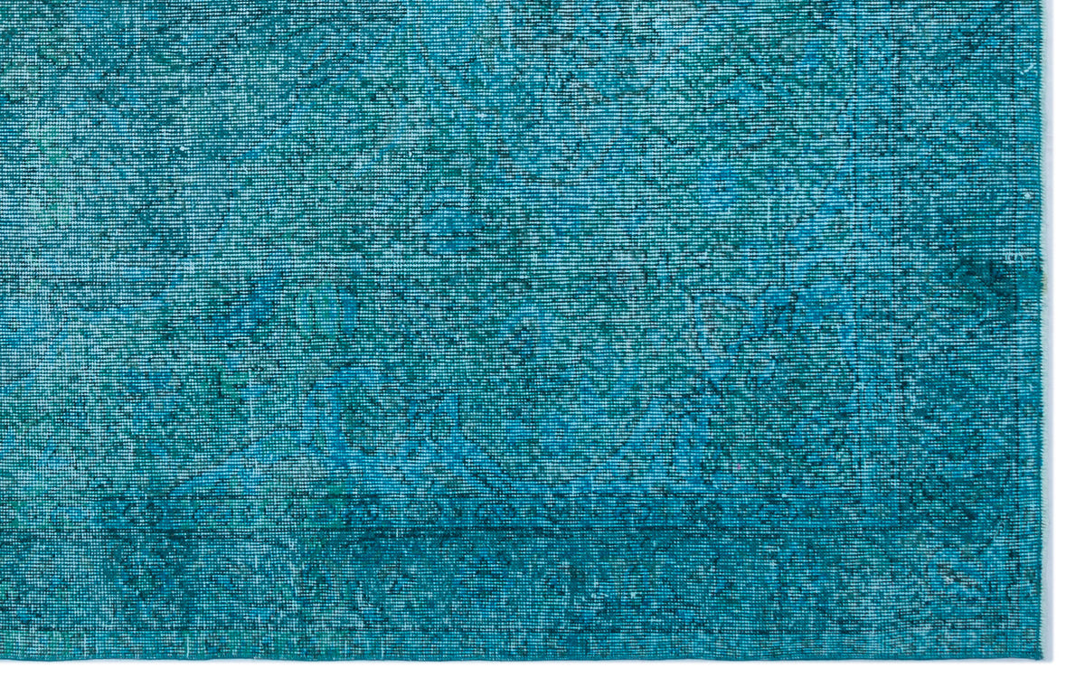 Teal and turquoise distressed rug with a faint, traditional Persian-style medallion pattern.