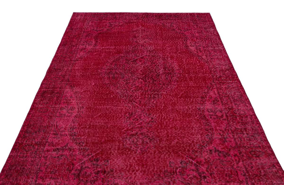 Deep red vintage-style rug with a faded, intricate central medallion pattern on a white background.