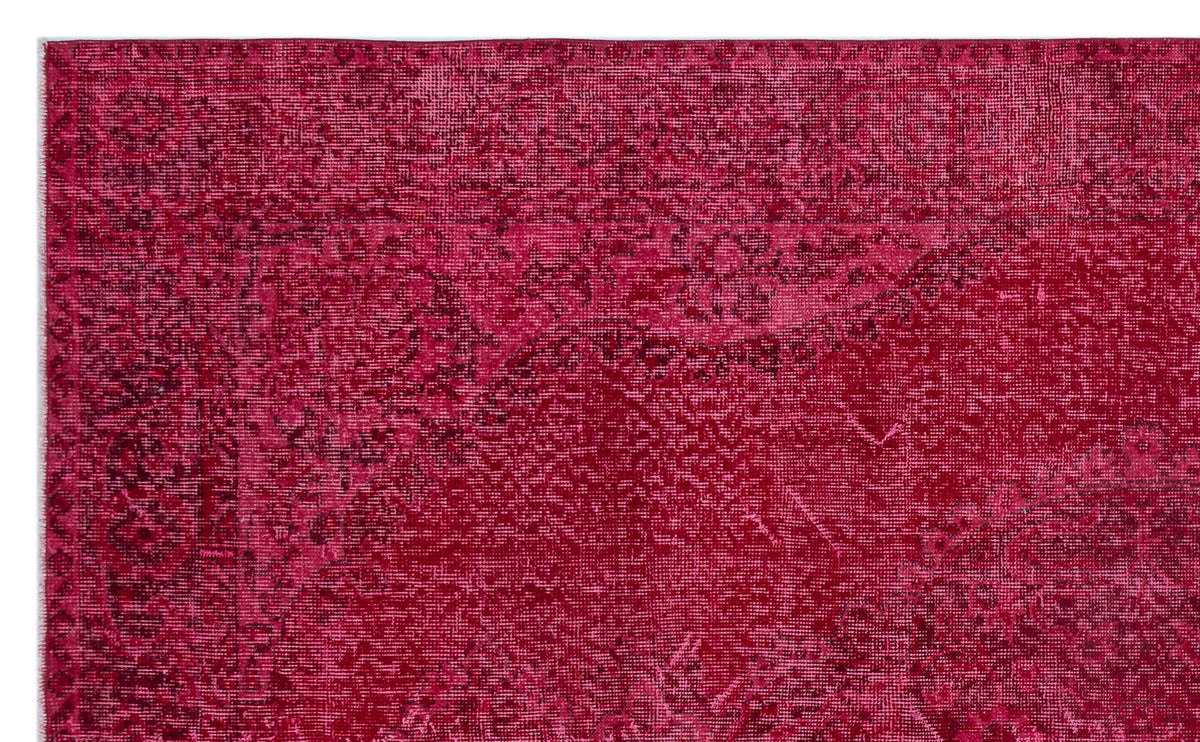 Deep magenta vintage-style rug with a distressed, faded traditional floral medallion pattern.