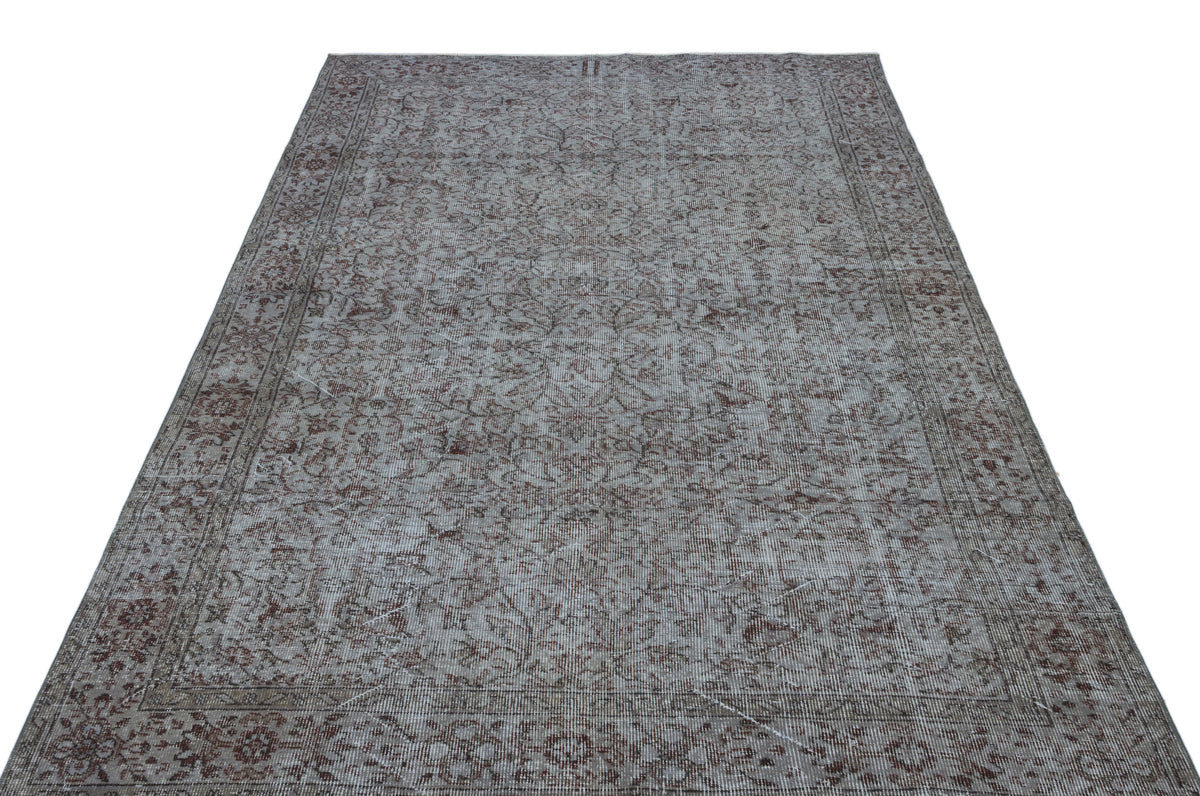 Grey and brown distressed vintage-style rug with an intricate floral pattern and a bordered frame.