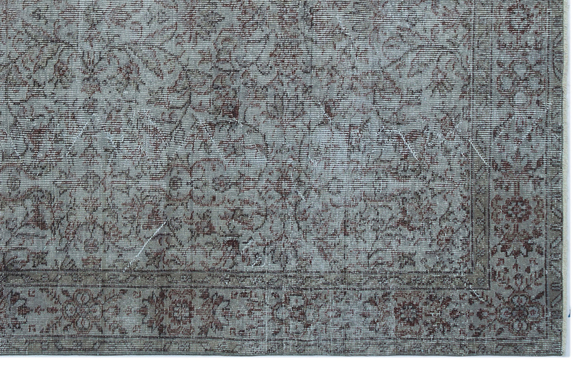 Distressed grey and rust-red traditional rug with an intricate floral medallion pattern and a detailed border.