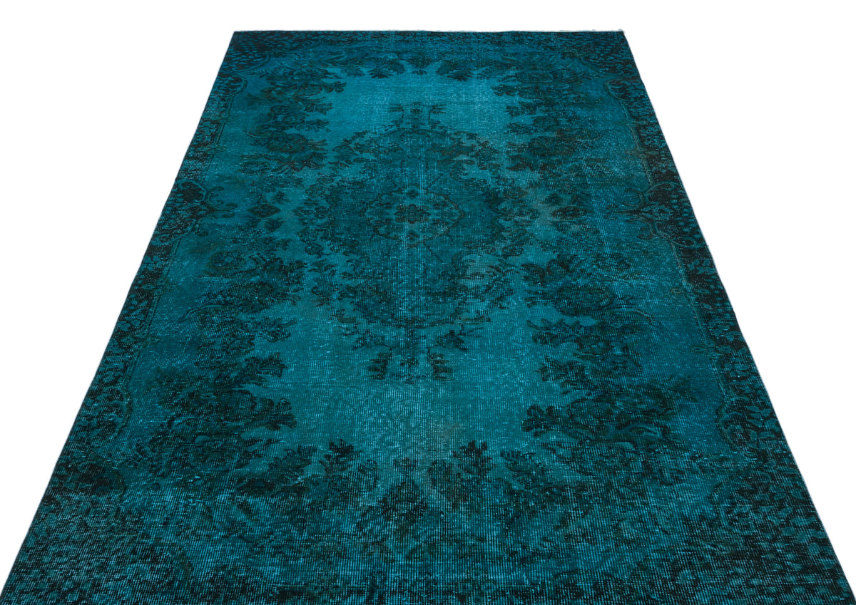 Teal and black distressed rug with a traditional floral medallion pattern on a white background.